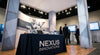 A professional trade show booth featuring a neatly draped table cover and tall fabric tube displays creating a cohesive, branded exhibit environment.