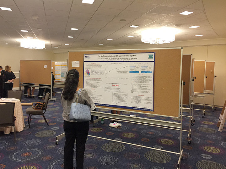 Person standing in front of a large presentation board in a conference room.